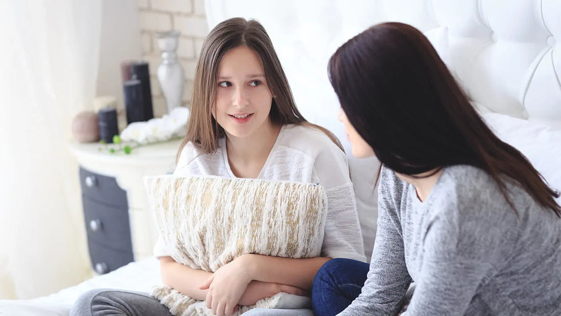 Mamă și fiică discutând deschis despre prima menstruație, într-un moment de încredere și sprijin.