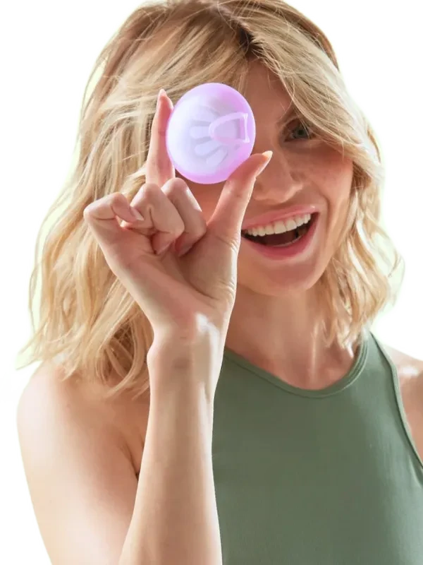 Femeie prezentând un disc menstrual FemiEko