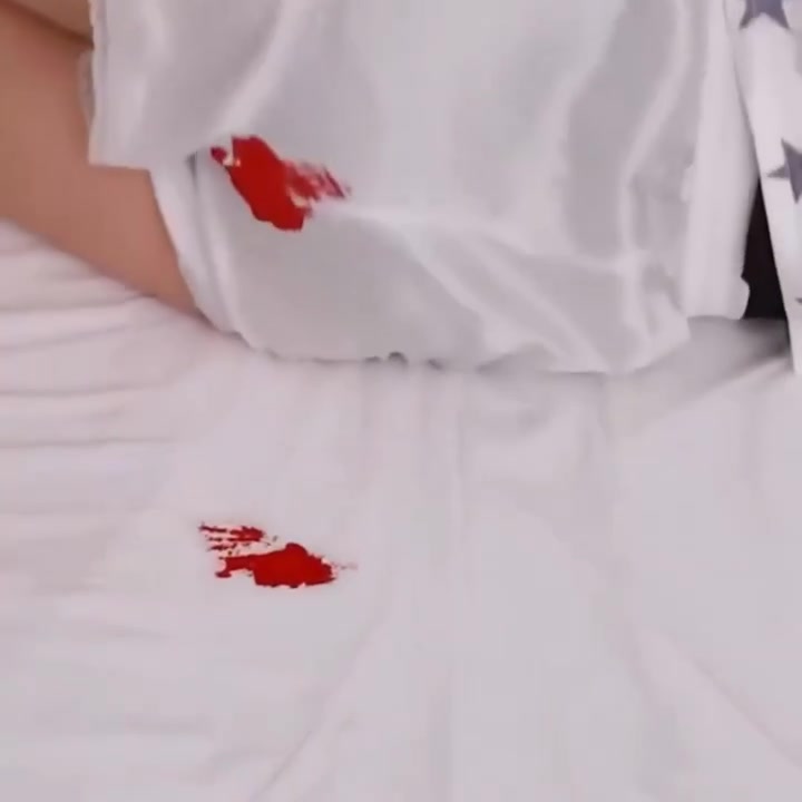 Pată menstruală pe un cearșaf alb, cadru din videoclipul Femieko